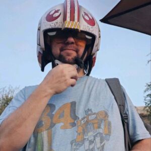 Client Daniel posing in a helmet on a ride in Disneyland