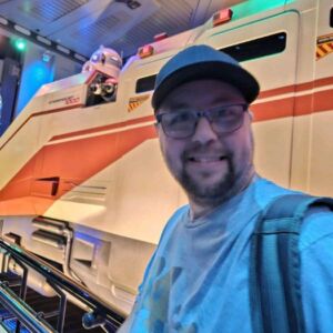 Client Daniel posing in front of the star wars ride at disneyland
