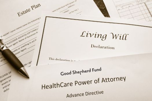 Paperwork including a Living Will, Estate Plan and Healthcare Power of Attorney Directive with black pen laying on top