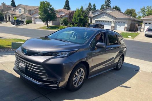 the 2020 toyota sienna is parked in front of a house