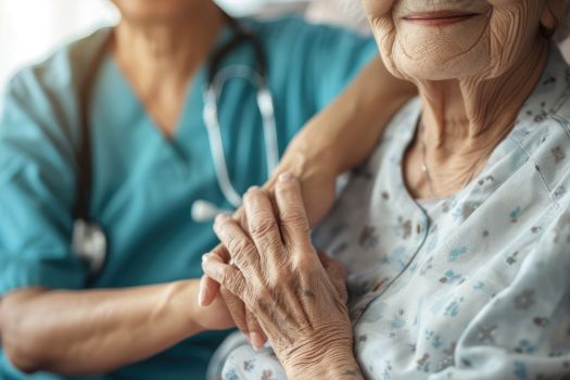 A person is holding the hand of a nurse