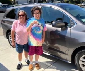 Two individuals standing in front of a car. Grace and her Mother.