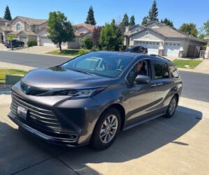 the 2020 toyota sienna is parked in front of a house