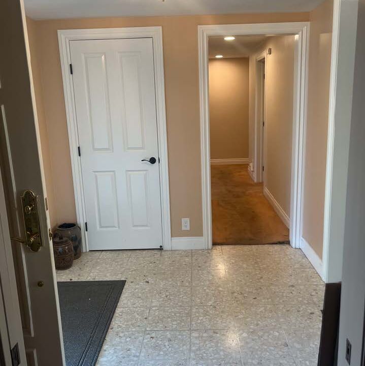 entry way with tile and hallway with brown carpet that is old & water stained