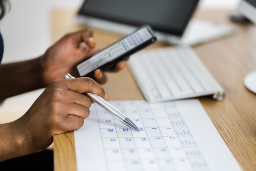 a person is using their cell phone while sitting at a desk