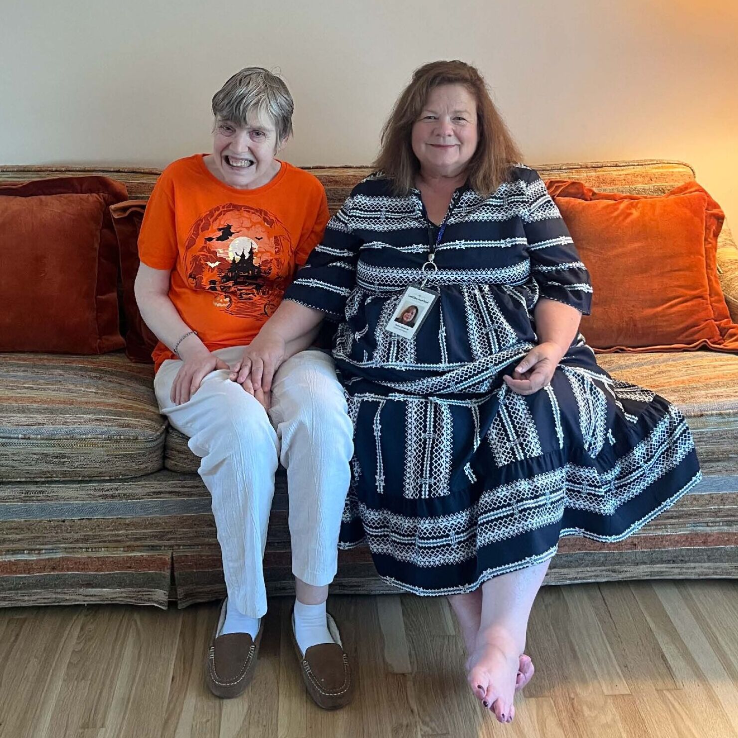 Pamela & Tammy sitting on a couch in a living room.