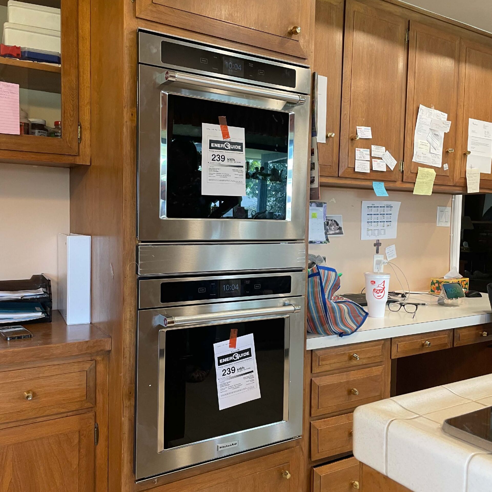 two ovens in a kitchen with wooden cabinets and counter tops